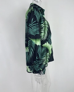 Detail of tropical print long sleeve shirt featuring green palm leaves and pleated cuffs