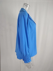 Detailed view of the vibrant blue lapel collar and elastic pleated cuffs of the summer top
