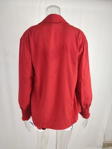 Detail view of the red long-sleeved shirt's back featuring elastic shirred cuffs