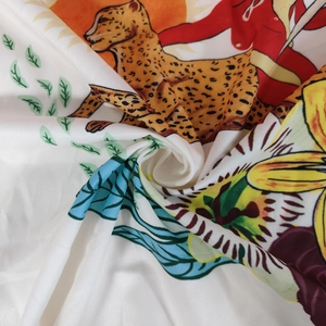 Vue détaillée du motif floral et léopard vibrant sur tissu satiné soyeux et brillant