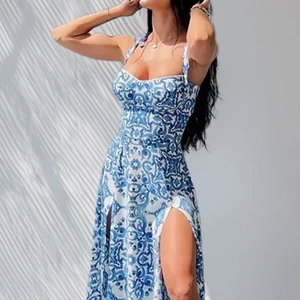 Détail de robe longue à fleurs bleu et blanc avec décolleté en cœur et fente latérale