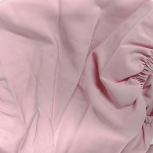 Detailed close-up of pink puff sleeve dress fabric with elastic smocking textures