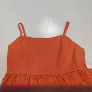 Dettaglio del top arancione in cotone lavato con trama plissettata e sottili spalline