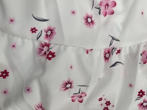 Detail shot of the V-neck dress featuring delicate pink floral print and chiffon texture
