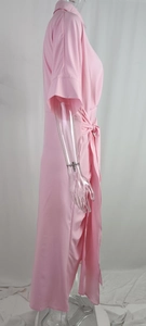 Vue latérale d'une robe chemise rose clair élégante avec ceinture et fente latérale
