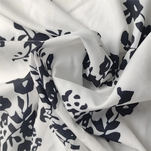 Gros plan sur un tissu en mousseline à imprimé floral noir et blanc avec des plis élégants