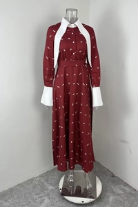 Gros plan sur robe bordeaux à imprimé floral avec col pointu blanc et poignets contrastants