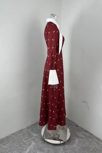 Détail d'une robe longue rouge cerise avec col Claudine et poignets blancs