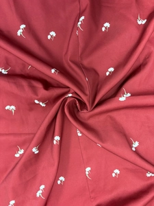 Détails du tissu rouge foncé avec petit imprimé floral blanc et texture fine