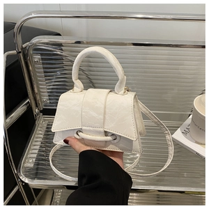 Close-up of white crossbody bag with wrinkled leather texture and rounded handle