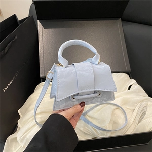 Light blue mini handbag with pleated texture and adjustable strap in hand display