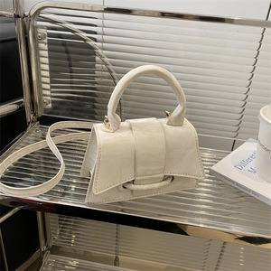 Minimalist white textured leather handbag with a round buckle and crossbody strap