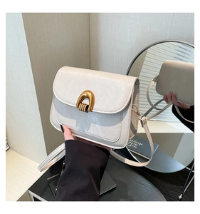Detailed macro shot of a cream PU leather bag featuring a gold arch-shaped buckle and strap