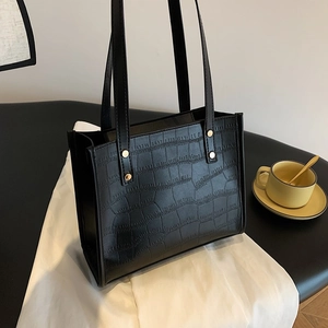 Classic black crocodile pattern tote bag with gold metal rivets for stylish daily commuting