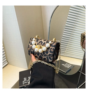 Detailed close-up of leopard print jelly bag featuring large pearl handle and gold chain