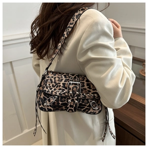 Detail of leopard print shoulder bag featuring metallic studs and buckle strap accents