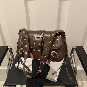 Dark brown leather shoulder bag featuring silver metal eyelets and moto-chic buckle details