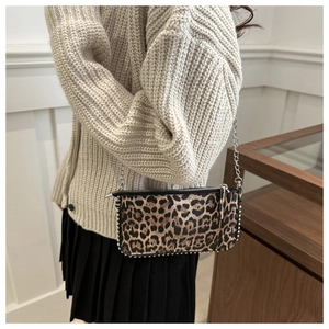 Detail of leopard print bag featuring silver studs and delicate metal chain strap
