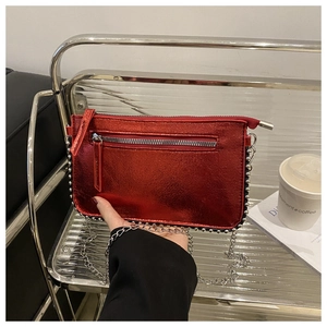 Detail of red metallic chain bag with silver bead trim and modern zip closure