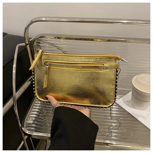 Detail of metallic gold shoulder bag with silver rivets and metal chain strap