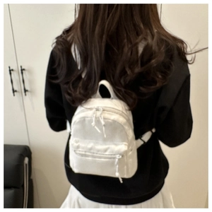 Detail view of white corduroy mini backpack with vertical texture and shoulder straps