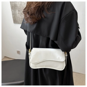 Close-up of a minimalist white glossy crossbody bag with irregular wavy flap edges