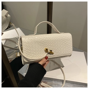 Detailed macro view of white woven texture leather bag featuring gold knotted metal buckle