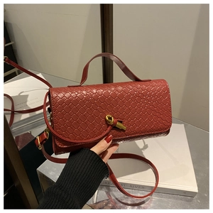 Detail showing rust red woven leather texture and gold knot-shaped metal twist lock