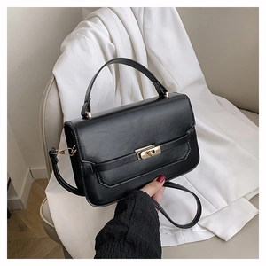 Gros plan détaillé d'un sac à bandoulière en similicuir noir avec un fermoir en métal chic