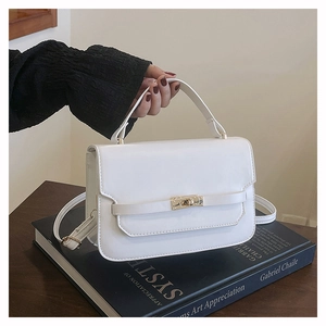 Détail du sac à main en cuir PU blanc avec fermoir tournant doré et bandoulière réglable