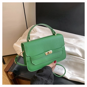 Détail du sac à main en cuir vert avec fermoir tournant doré et bandoulière réglable
