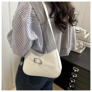 Detailed side view of a white crescent shoulder bag featuring decorative metal buckle strap