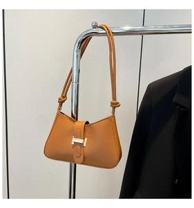 Détail du sac croissant en cuir marron caramel avec boucle H dorée et bandoulière nouée