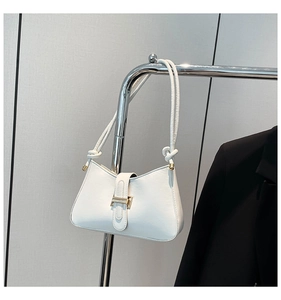 Détail de la boucle en métal doré poli et du cuir blanc sur le sac à bandoulière en croissant