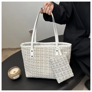Detail of tweed tote bag set featuring white and gold plaid texture and leather trim