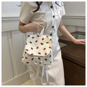 Detailed view of strawberry print corduroy backpack with drawstring and flap closure