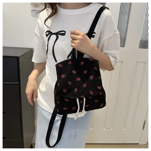 Detailed texture of strawberry print on corduroy fabric with white drawstring closure