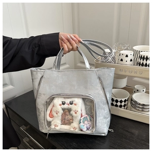 Detail of silver metallic ita bag with large transparent window and plush bunny ears decor
