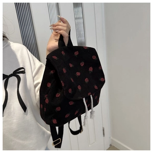Detail of strawberry print corduroy bag showing white drawstring and black strap texture