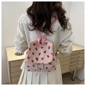 Pink corduroy mini backpack with red strawberry pattern and white drawstring detail