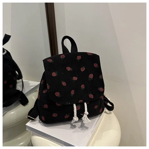 Detail of black corduroy mini backpack with red strawberry print and white tassel drawstrings