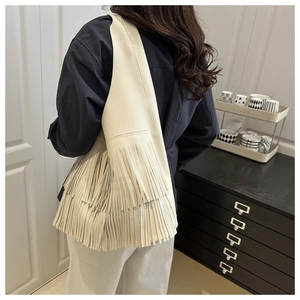 Detail of cream fringe hobo shoulder bag with layered leather tassels and soft texture