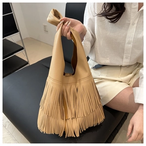 Detail of bohemian fringe tassel hobo bag in apricot leather with knot handle design