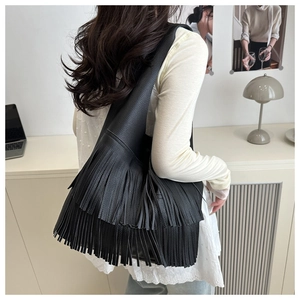 Detailed view of black fringe hobo bag featuring three layers of soft faux leather tassels