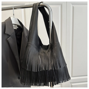Close-up of black litchi grain leather tote bag featuring stylish double-layer fringe tassels