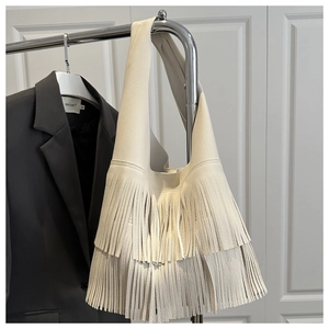 Detailed view of cream hobo bag featuring premium lychee texture and long double tassels