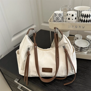 Minimalist beige tote bag with brown straps and dual front zippers for daily commute