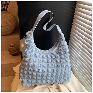Détail du sac bulle bleu clair avec texture plissée 3D et breloque fleurie grise