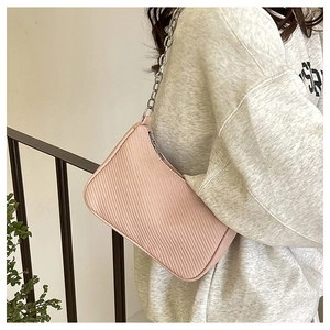 Close-up of pink textured crescent bag with stylish thick silver metal chain strap