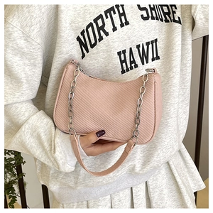Detailed view of pink woven texture crossbody bag with elegant silver chain strap decoration